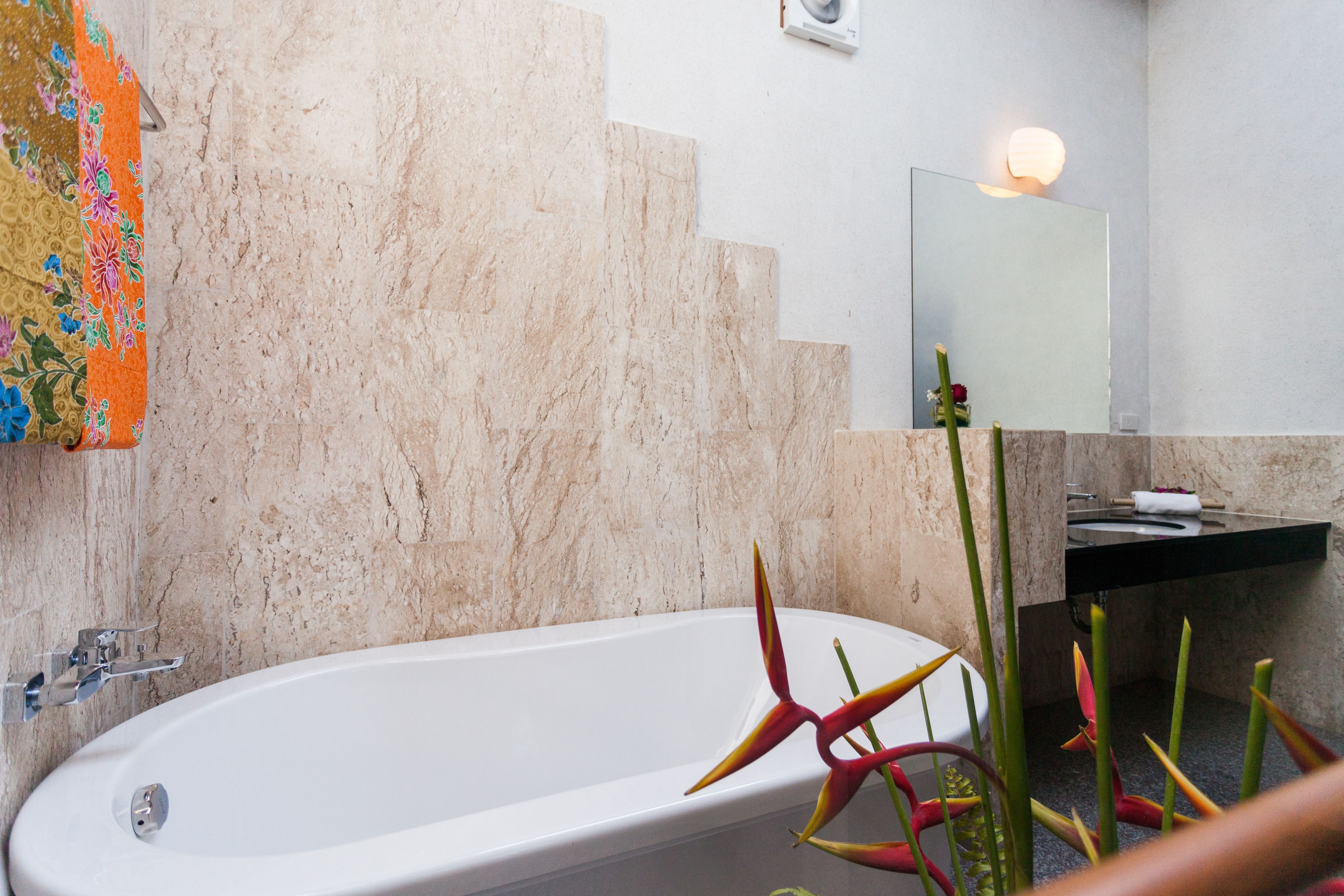 Une salle de bain avec une baignoire, un lavabo et un miroir.
