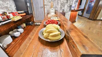 Una mesa de bufé con diversos alimentos y un microondas al fondo.