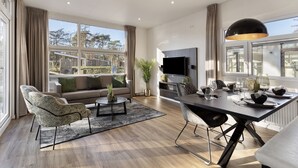 Un salon moderne avec un canapé, une table basse et un coin repas.