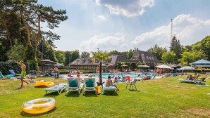 Un área de piscina con sillones de descanso y flotadores hinchables.