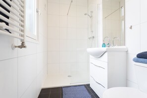 Un baño moderno con ducha, inodoro y lavabo.
