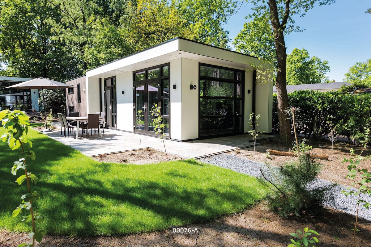 A modern house with a patio, a dining area, and a small garden.