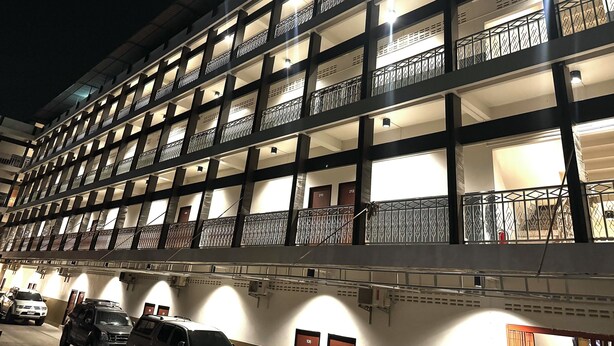 A multi-story parking garage with illuminated balconies and a clear view of parked vehicles. - Tokyo Hotel Korat (Nakhon Ratchasima)