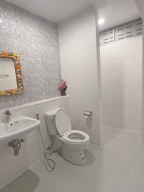 A bathroom with a sink, toilet, and shower area. - Tokyo Hotel Korat (Nakhon Ratchasima)