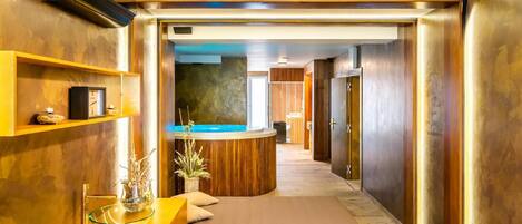 A modern hotel lobby with a reception desk, a seating area, and a view of the pool area.