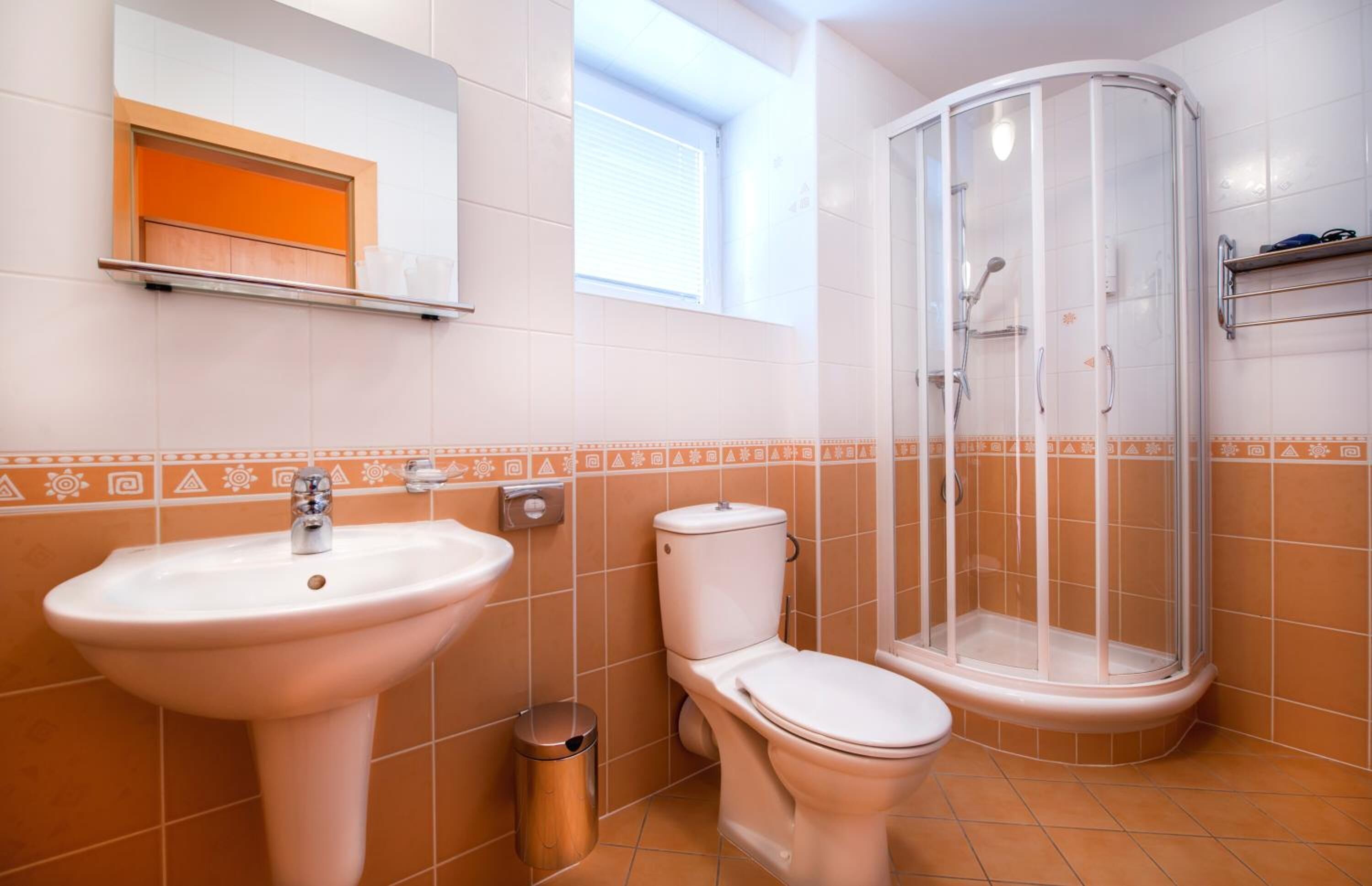 A bathroom with a sink, toilet, and shower.