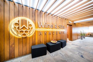 Un área de recepción con una pared de madera y un letrero que dice 'Wine & Spa Academy'.