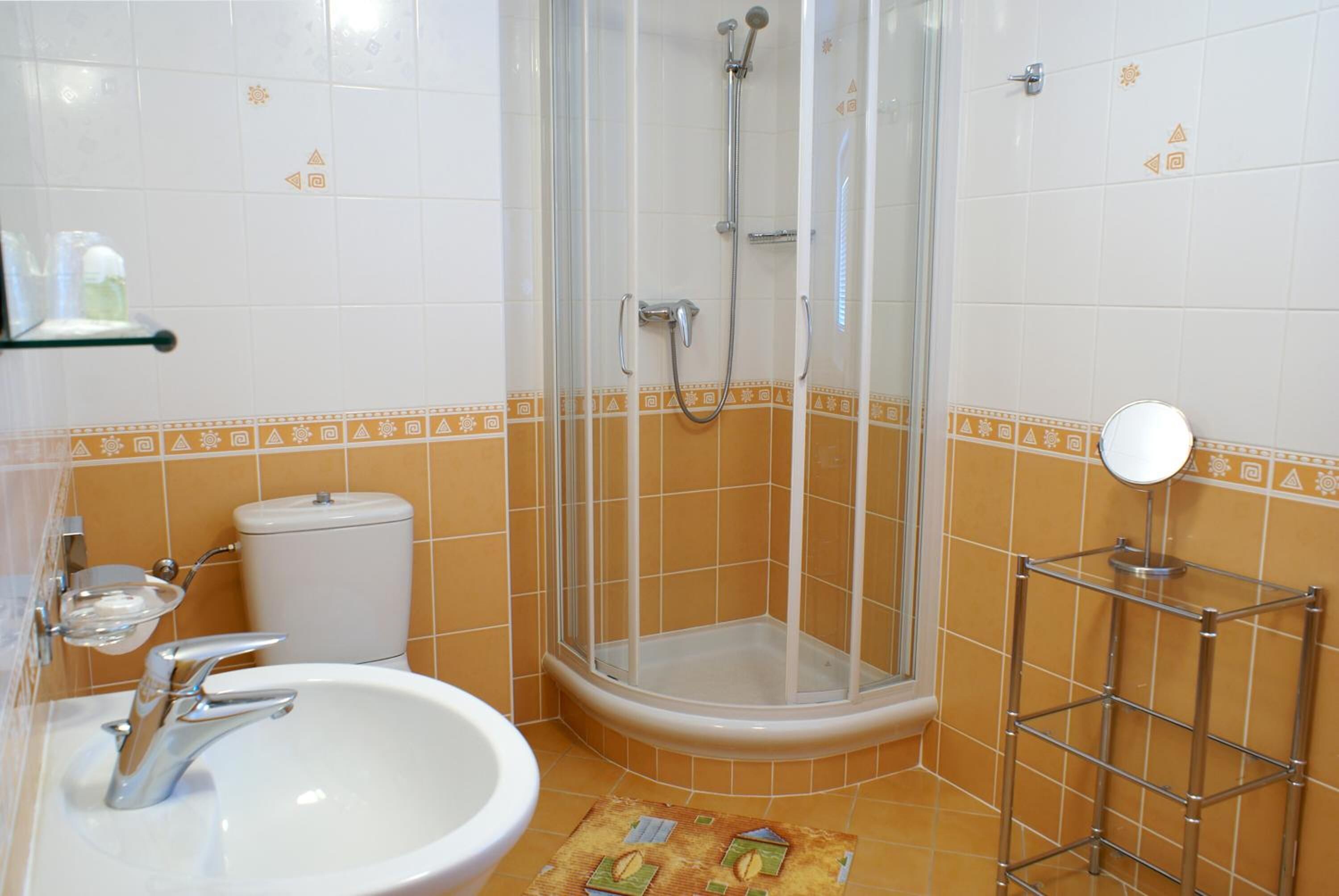 Une salle de bain avec une douche à parois de verre, un lavabo blanc et des toilettes.