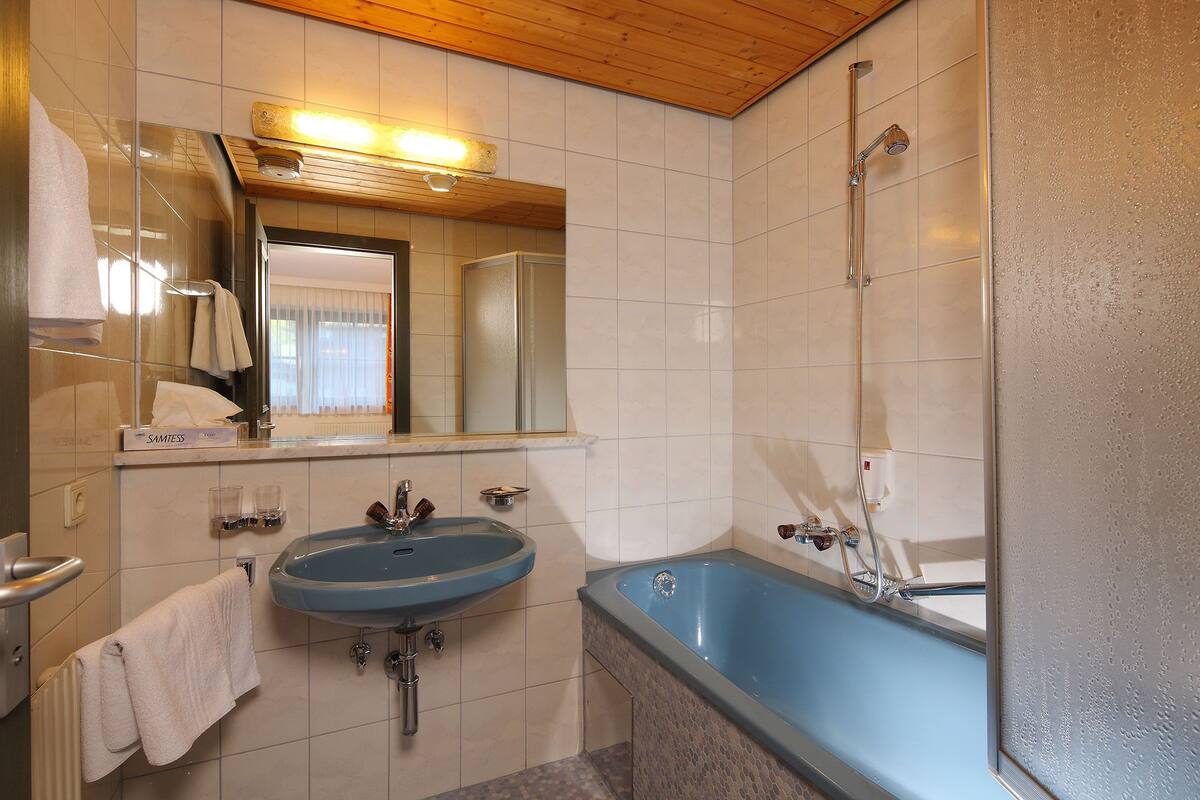 Ein Badezimmer mit Waschbecken, Spiegel und Dusche.