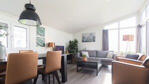 Una sala de estar moderna con comedor, un conjunto de sofás y una mesa de centro.