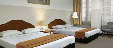 Una camera d'albergo con due letti, una sedia, un quadro appeso al muro e una finestra con tende.