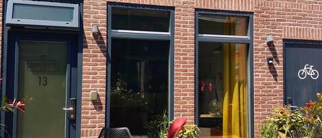 Een gebouw van baksteen met een pannendak, een deur met de tekst 'LOSKADE45' en een fietssymbool dat aangeeft dat fietsen hier welkom zijn.