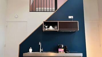 A modern kitchen with a built-in stove, a sink, and a countertop with a coffee maker.
