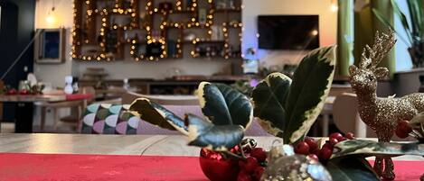 A cozy living room with a red carpet, decorative plants, and a Christmas tree.