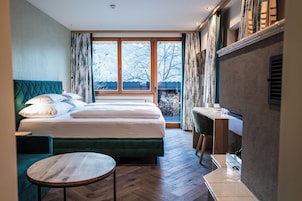 Habitación de hotel con una cama grande, un escritorio y vistas al exterior.