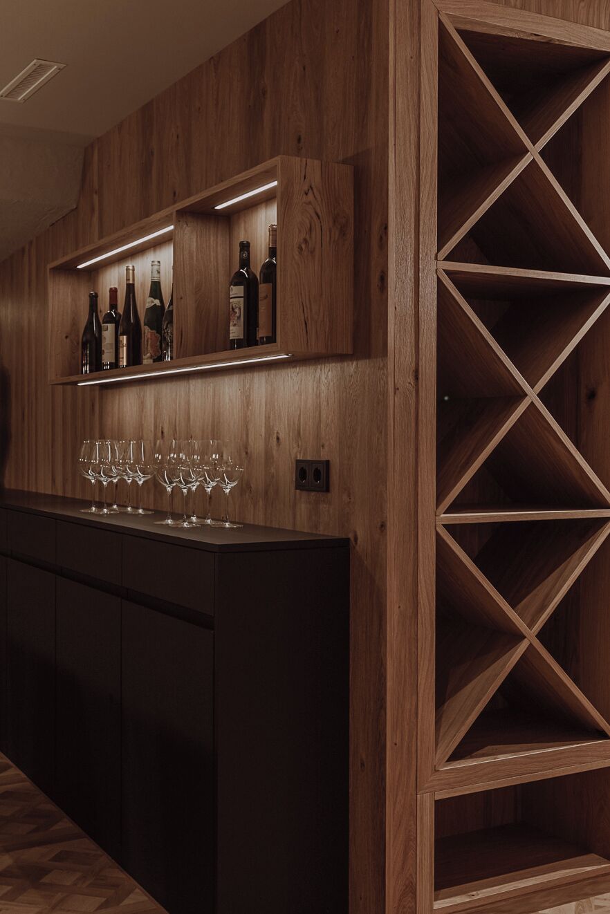 Una zona de bar con estantes de madera y un botellero.