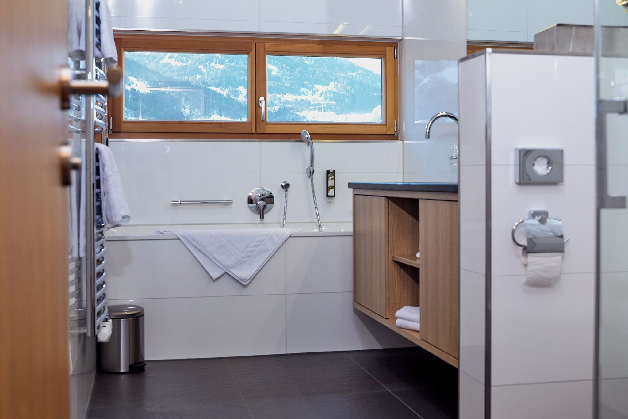 A modern kitchen with a window view, a sink, and a refrigerator.