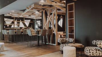 Un espace bar moderne avec des poutres en bois, des tabourets de bar et un comptoir.