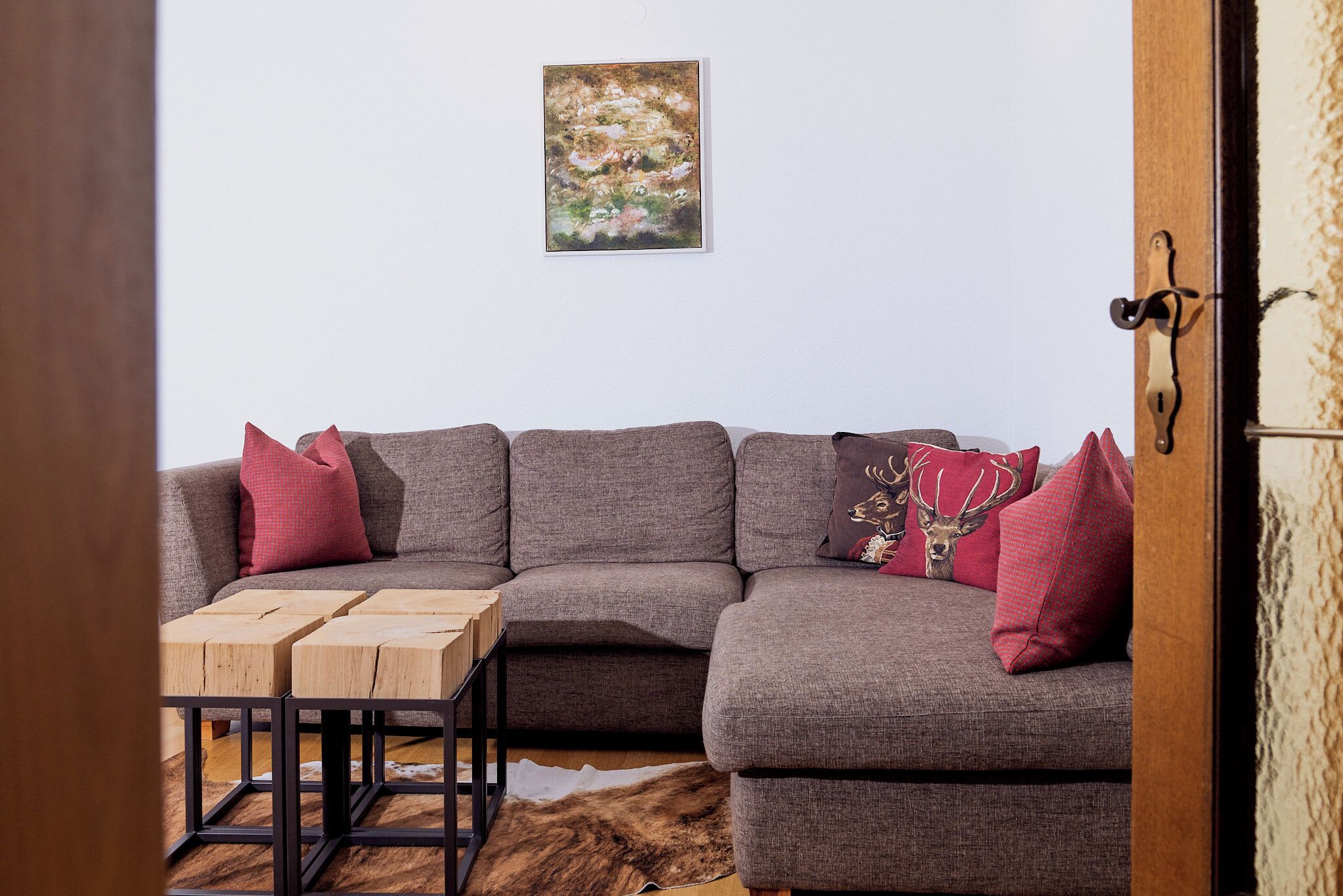A living room with a sectional sofa, a wooden coffee table, and a cowhide rug.
