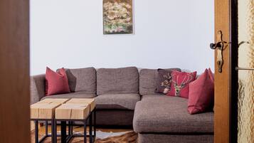 A living room with a sectional sofa, a wooden coffee table, and a cowhide rug.