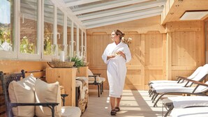 A spa area with wooden walls, a glass ceiling, and sun loungers. - Alpenrose Aktiv & Spa (Schruns)