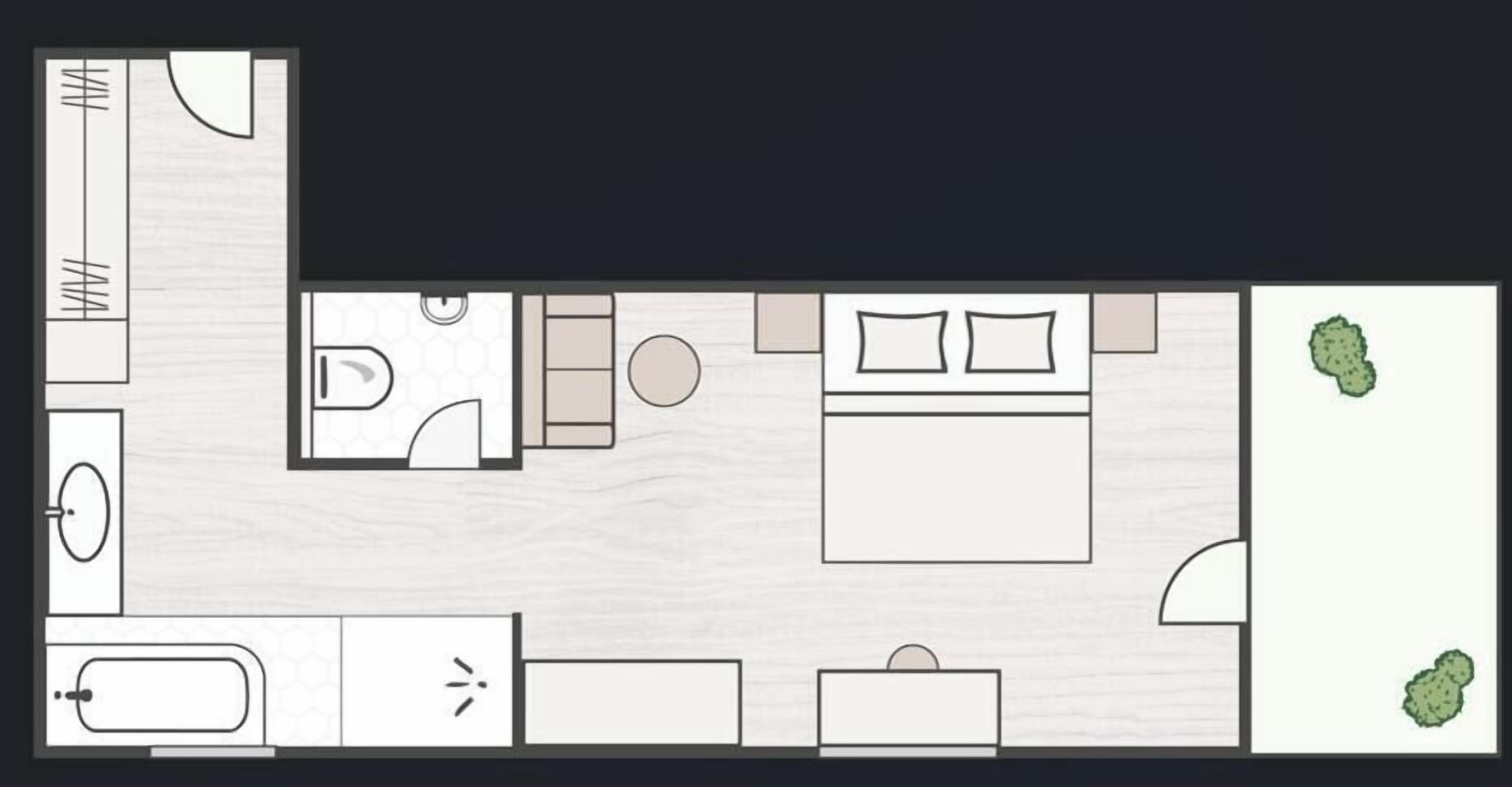 A hotel room layout with a bed, a bathroom, a small seating area, and a kitchenette.