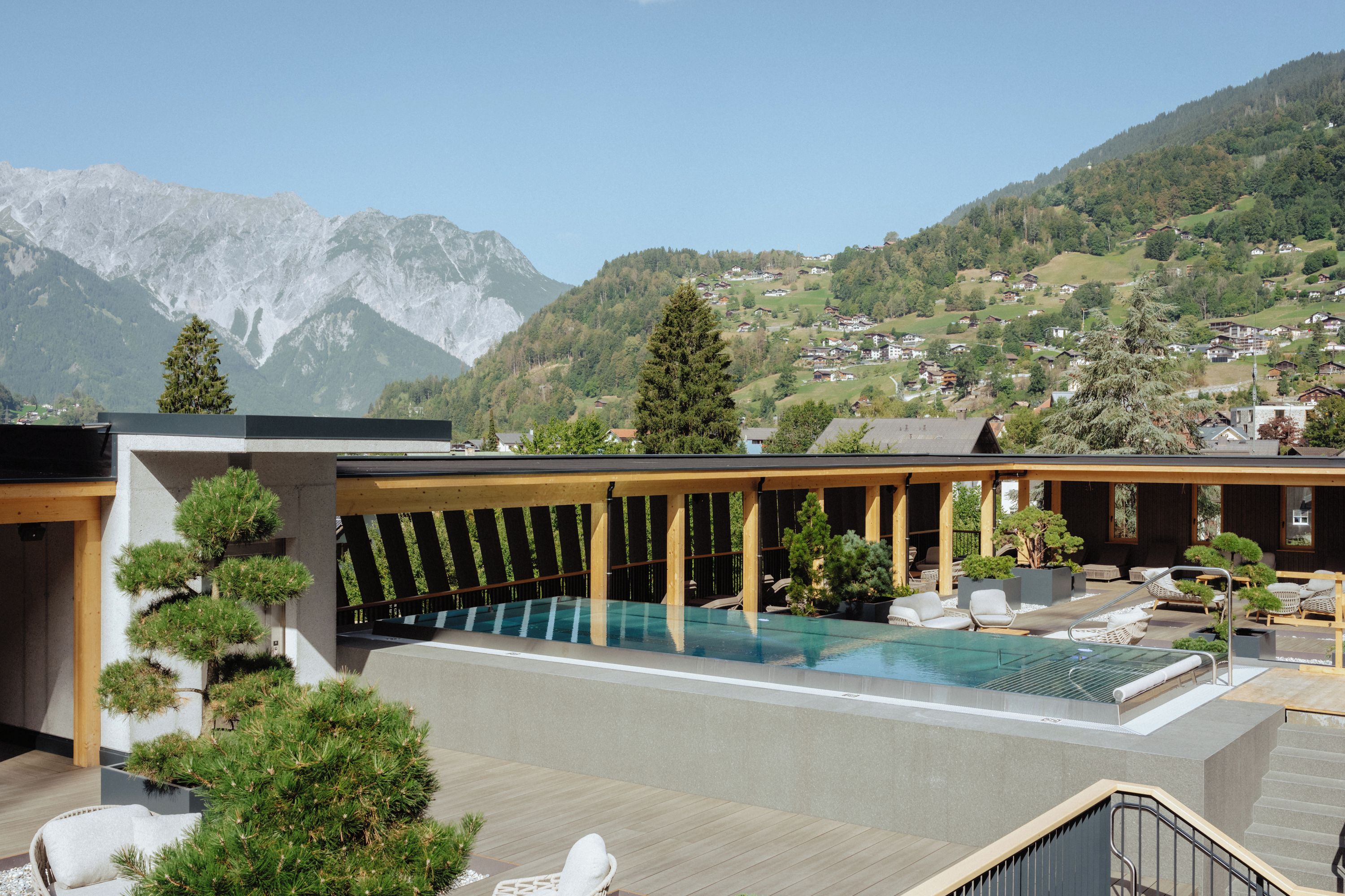 A rooftop pool area with a view of a mountainous landscape.