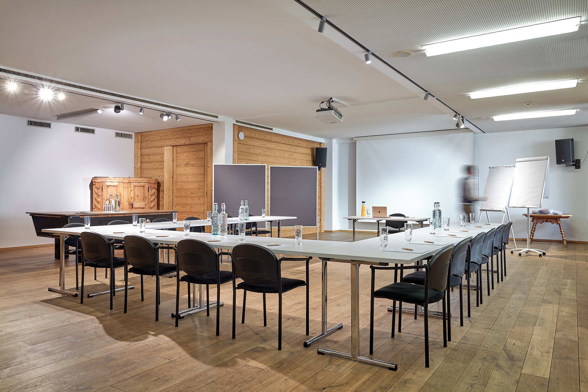 A conference room with a long table, chairs, a whiteboard, and a projector.