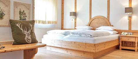 Ein Schlafzimmer mit Holzrahmen, einem Bett, Nachttischen und einer Bank.