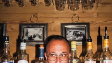 A bar area with various liquor bottles and hanging wine glasses.