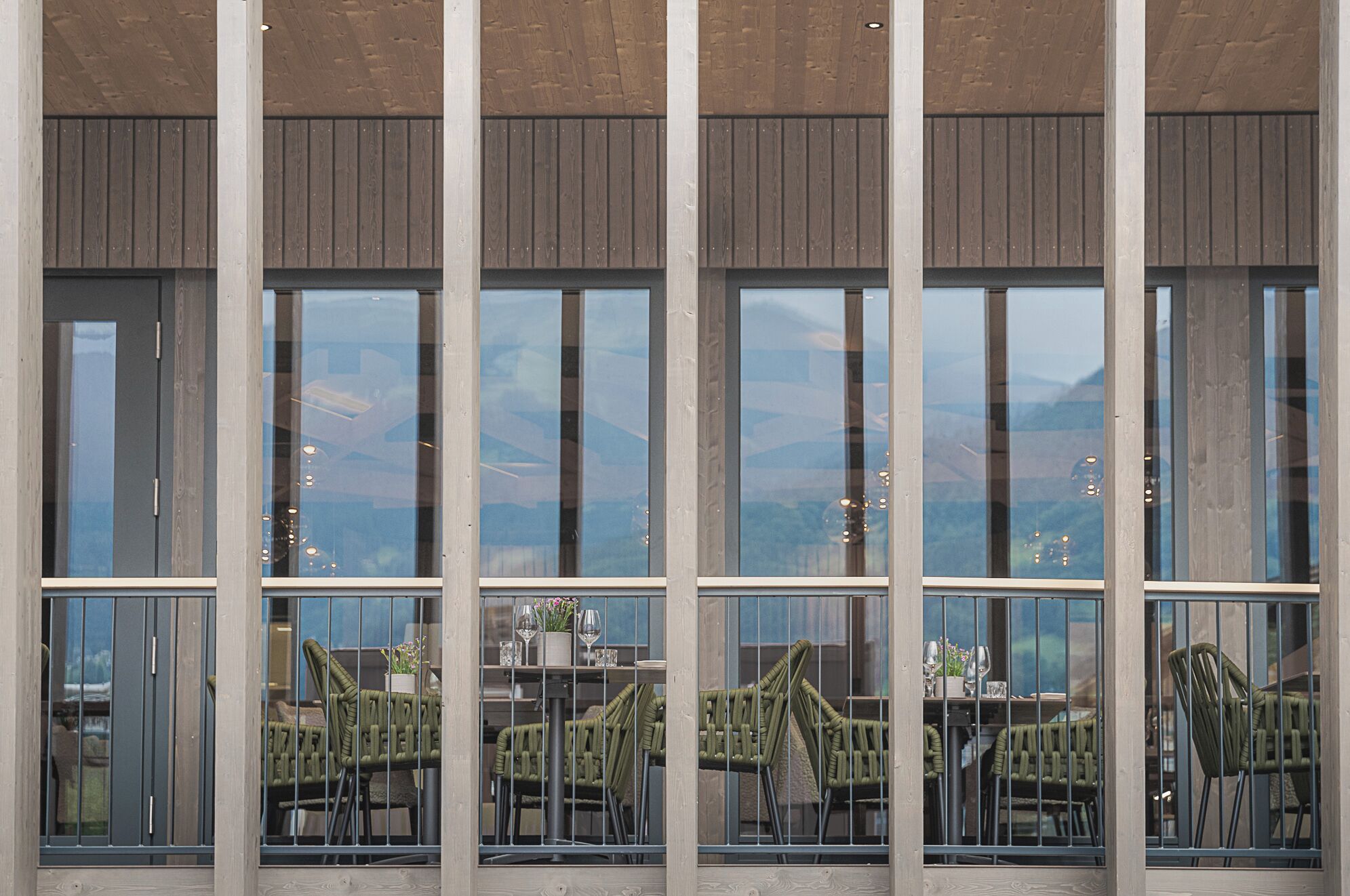 A restaurant with large windows and outdoor seating.