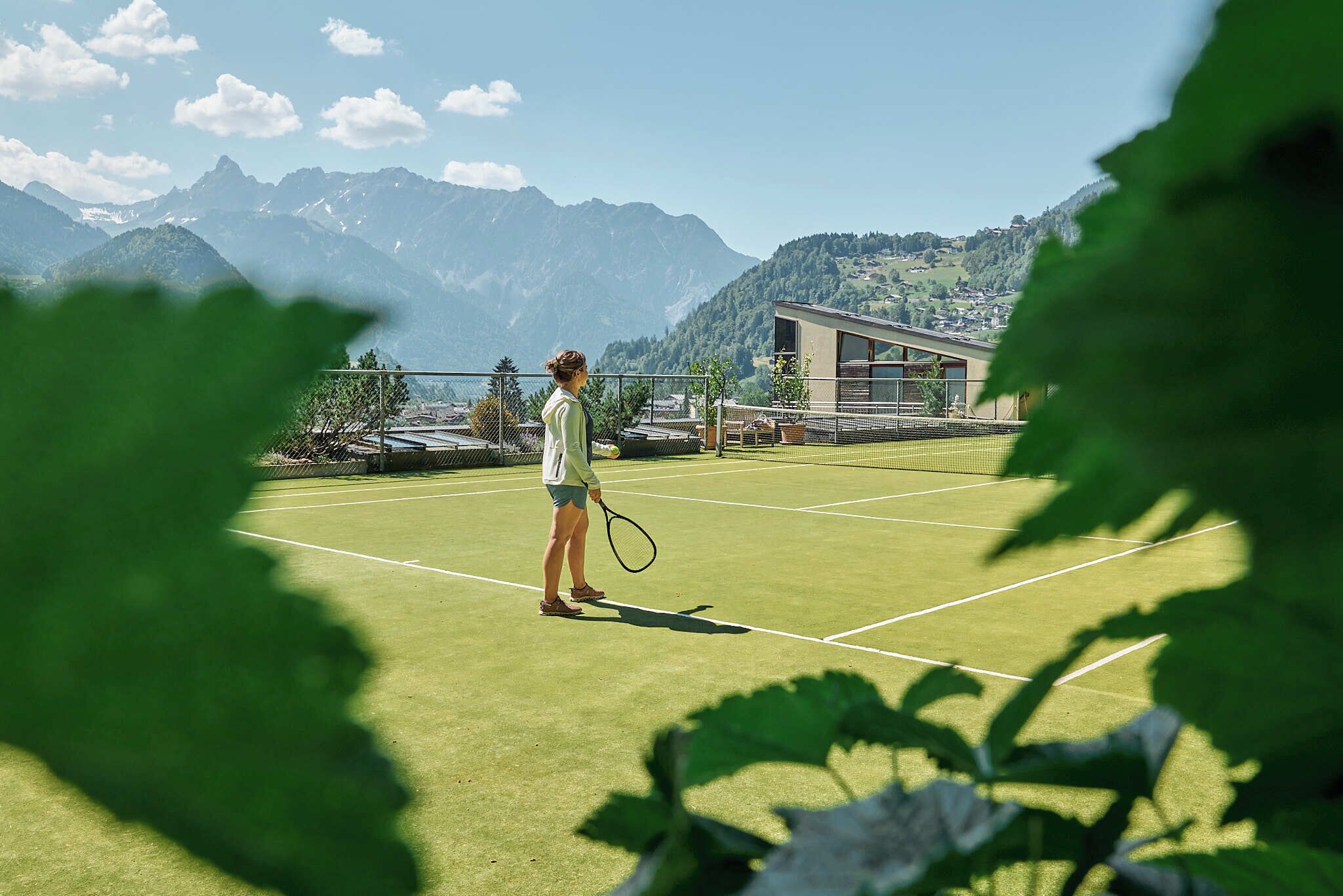 Ein Tennisplatz mit Bergen im Hintergrund.