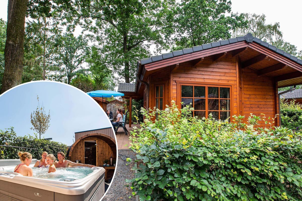 A wooden cabin with a hot tub, surrounded by lush greenery.