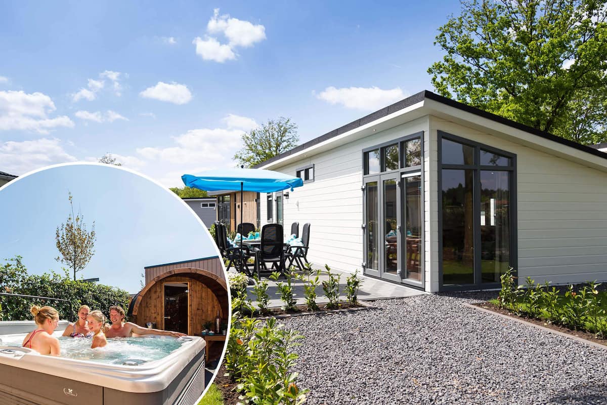A modern house with a patio, a hot tub, and a dining area with a blue umbrella.