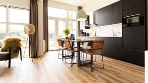 Una cocina moderna con zona de comedor, ventanas amplias y vistas al exterior.
