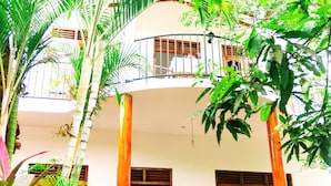 A two-story building with a balcony, surrounded by lush greenery. - Wayside Guest (Mirissa)