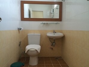 A bathroom with a toilet, sink, and mirror.