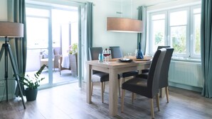 Un comedor moderno con una mesa de madera, cuatro sillas y una lámpara colgante.