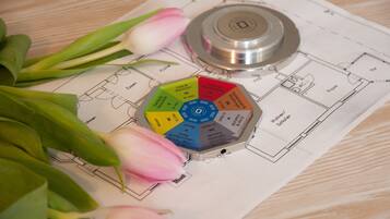 A floor plan with a central circular diagram, a mechanical device, and pink tulips.