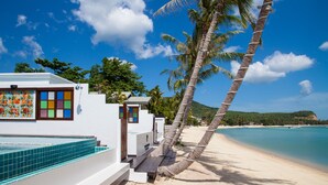 A beach house with a pool, a hammock, and a view of the ocean. - The Privilege Hotel Ezra Beach Club (Koh Samui)