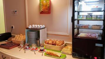 Ein Frühstücksbuffet mit verschiedenen Speisen und ein Kühlschrank mit Milchprodukten.