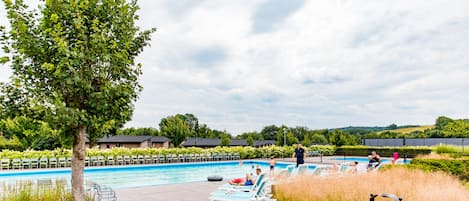 Una piscina al aire libre de temporada, tumbonas