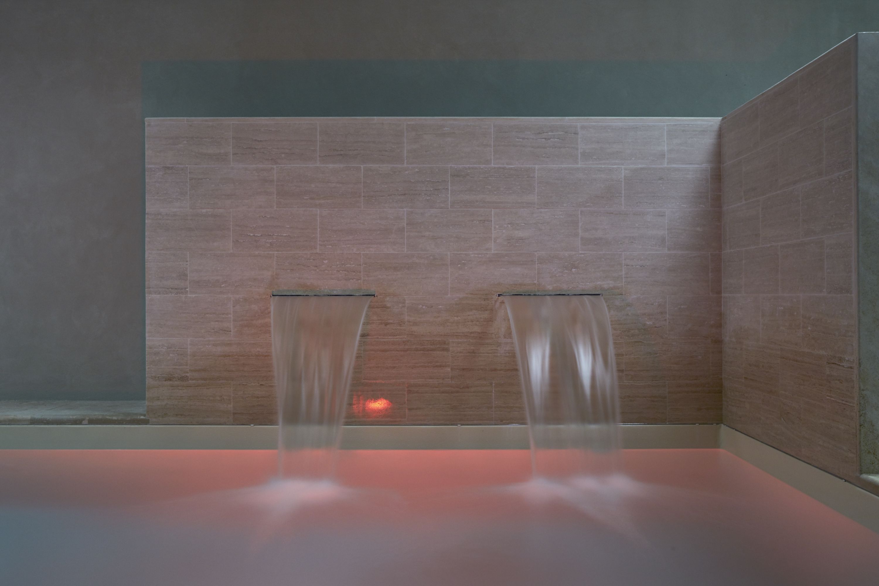 A modern bathroom with two sinks and a shower area.