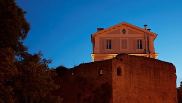 A building with a classical architectural style, situated atop a brick wall.
