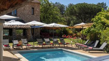 Een buitenzwembad en ligstoelen