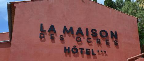 A building with the sign "LA MAISON DES OECRES HOTEL".