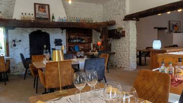 Un interior rústico con una zona de bar, muebles de madera y paredes de piedra.