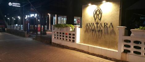 The exterior of Avatar Resort with a prominent sign, a paved walkway, and a well-lit entrance area.