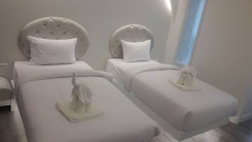 Una habitación de hotel moderna con dos camas, cada una con cabecera y almohada.