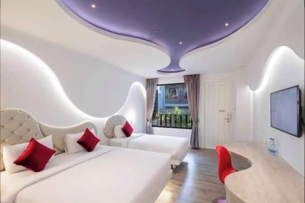 Deluxe Triple Room | Minibar, in-room safe, desk, blackout drapes